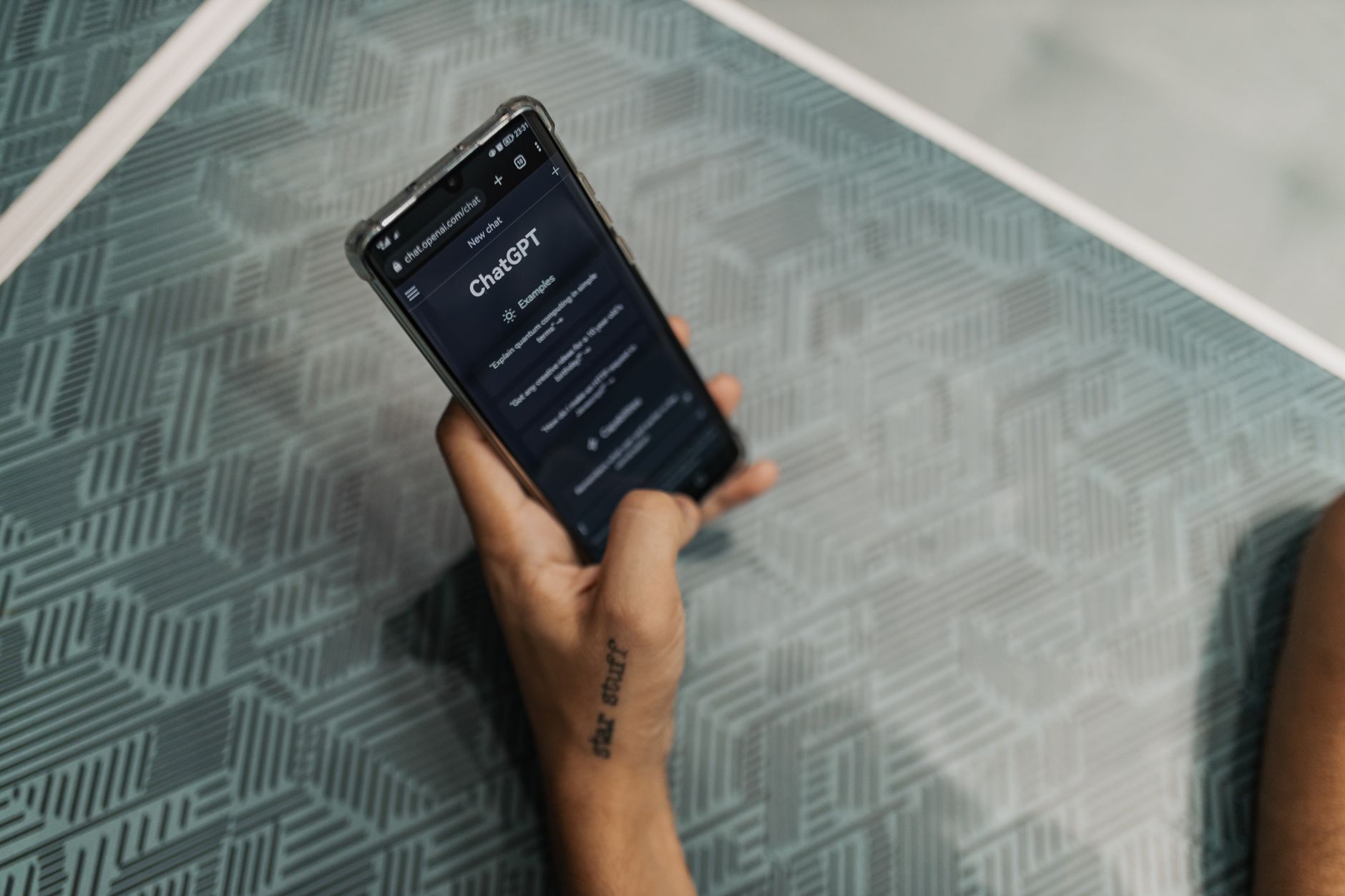 Person holding iPhone showing ChatGPT app chat screen with AI response